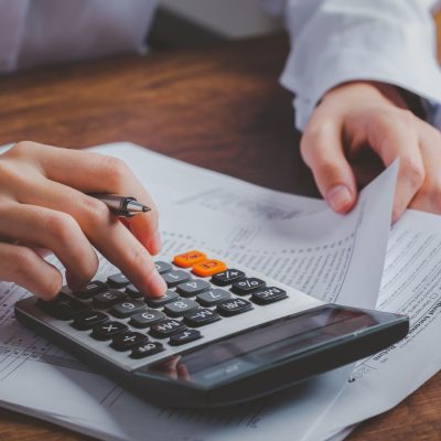 A small business owner calculating their accounts receivable on a calculator.