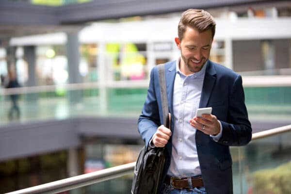 business professional reviewing financial data on phone in modern office setting