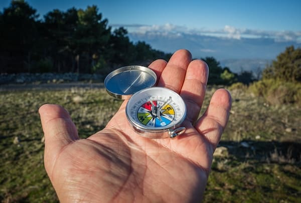 Hand holding a compass outdoors symbolizing business owners checking if their bookkeeping and financial direction are accurate
